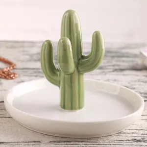 Ceramic cactus jewelry tray with gold accents for rings and necklaces on a wooden desk