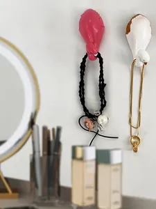 Detail of pink and white flamingo wall hooks holding jewelry and hair accessories