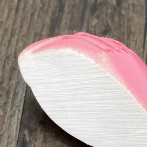 Macro shot of flamingo wall hook showing pink resin texture and fine detail on dark wood