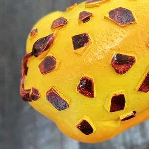 Macro view of cartoon animal skin texture with raised 3D brown spots on a yellow base