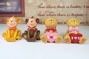 Detailed view of monkey and bear resin phone holders with I Love You heart elements