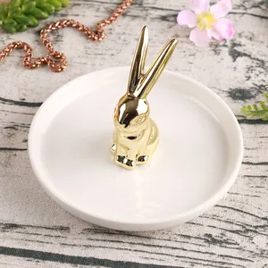 Nordic white ceramic jewelry tray with gold bunny ring holder on wood background