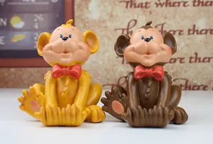 Detail of creative resin monkey phone holders in yellow and brown with red bow ties