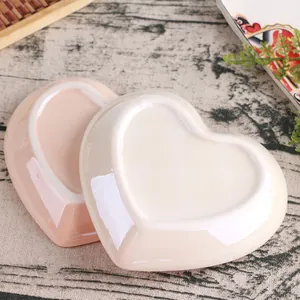 Bottom view of heart-shaped ceramic jewelry trays in pink and white with smooth glaze