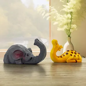 Modern geometric elephant and giraffe resin statues on a wooden table for home decor