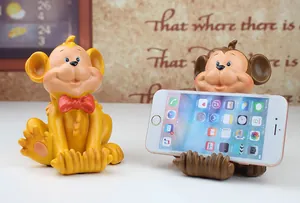 Creative monkey resin phone holder in brown and yellow colors for desktop display
