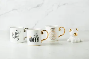 Detailed view of luxury ceramic mugs with gold handles and a geometric bear ornament