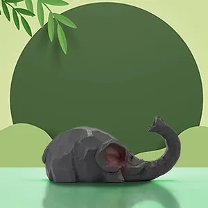 Detail of faceted grey elephant figurine with red ears on a modern green background