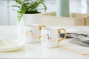 Detail of Mr and Mrs gold lettering on luxury white ceramic mugs with golden handles