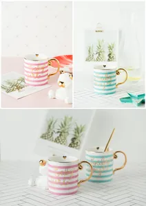 Close-up of gold-plated handle and rim on ceramic mugs with Baby girl and Baby boy text