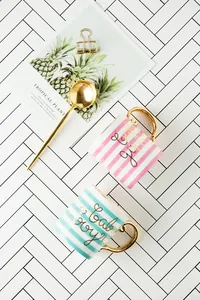 Detail of pink and blue ceramic mugs with gold lettering baby girl and baby boy
