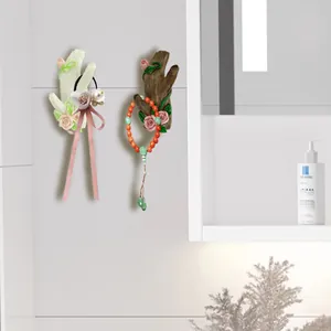 Detail of tree branch wall hooks with floral relief used for hanging jewelry and bands