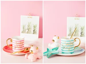 Detailed view of gold-rimmed ceramic mugs with baby girl and boy lettering