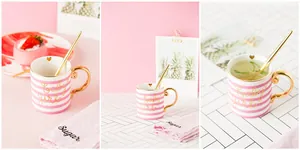 Detail of pink striped ceramic mug with gold handle, baby girl script, and matching spoon