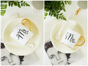 Detail of Mr and Mrs ceramic mugs with golden handles, matching lids and long spoons