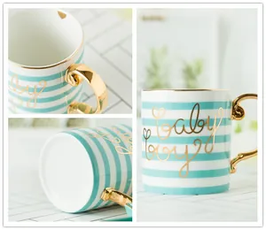 Detail of ceramic mug with mint green stripes, gold handle and baby boy lettering