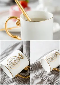 Detailed view of white ceramic mug with gold handle and to have & to hold ring design