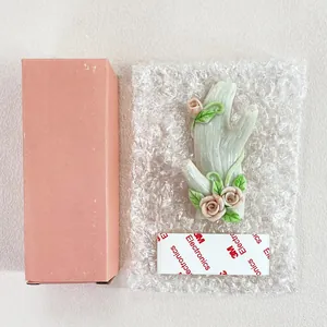 Detail view of branch-shaped wall hook with rose buds, packaging, and 3M adhesive