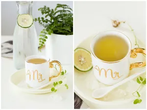 Detail of luxury white ceramic cup with gold handle and Mr engraving and matching saucer