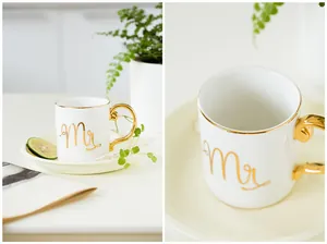 Detail of white ceramic mug with gold-plated handle, rim, and elegant 'Mr.' lettering