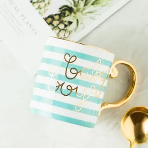 Detail of blue striped ceramic mug with gold handle and Baby Boy inscription
