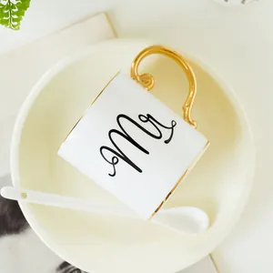 Detail of luxury ceramic Mr mug with elegant gold handle and matching spoon and saucer