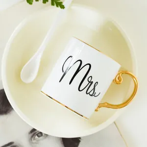 Detail of Mrs. ceramic mug with gold rim and elegant scroll-shaped handle in high-end style