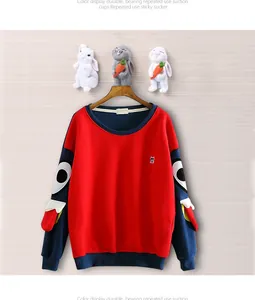 Detail of flamingo wall hook holding a red and navy blue cartoon sweatshirt