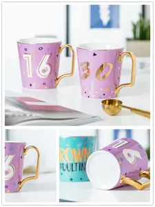 Dettagli di tazze in ceramica con manico dorato e testo Grown Adulting per regalo