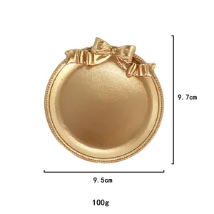 Détail d'un plateau à bijoux doré en résine avec nœud, 9,7 cm de haut et 9,5 cm de large
