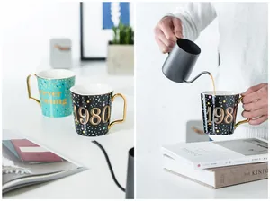 Dettagli di tazze di lusso in ceramica con manici dorati e stampa artistica per caffè o latte