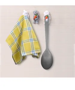 Detail of cartoon bunny wall hooks holding a kitchen towel and a stainless steel spoon