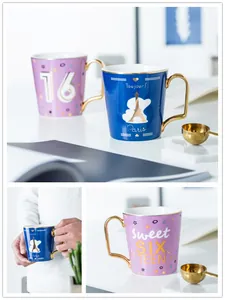 Dettagli di tazze di lusso in ceramica con manici dorati e design Sweet 16 e Parigi