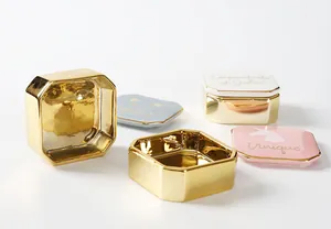 Detail von achteckigen Keramik-Schmuckdosen mit Goldbeschichtung und Slogan-Deckeln
