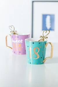 Dettaglio di tazze di lusso in ceramica viola e verde con manici e cucchiai d'oro