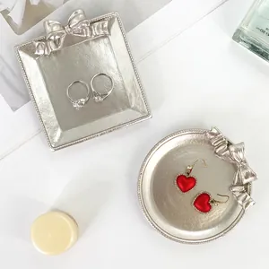 Détail du plateau à bijoux en résine argentée avec nœud pour boucles et bagues