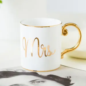 Elegant white ceramic mug with gold rim and Mrs inscription plus ornate gold handle