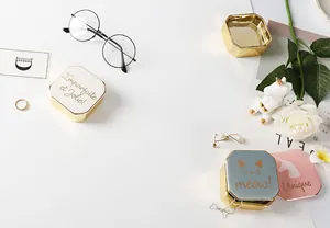 Nahaufnahme von achteckigen Keramik-Schmuckdosen mit Goldmetallboden und Kunstschriftzug