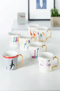 Tazze in ceramica con motivi animali e manici dorati in un ambiente domestico moderno