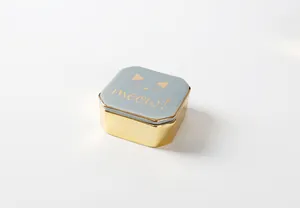 Detail einer Schmuckdose mit grauem Deckel, goldenem Katzenmotiv und Meow Schriftzug
