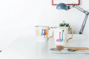 Dettaglio di tazze in ceramica di lusso con manici dorati e illustrazioni di animali