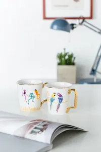 Dettaglio di tazze in ceramica di lusso con manici dorati e illustrazioni di animali