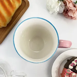 Flat lay of hand-painted ceramic reindeer mug with wood tray and fresh pastry