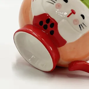 Macro detail of hand-painted ceramic mug base with Maneki Neko design and glazed finish