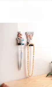 Detail of chef-themed wall hooks for bathroom toothbrush storage on tiled wall