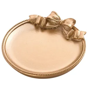 Plateau à bijoux nordique avec nœud doré champagne et bord perlé pour boucles d'oreilles