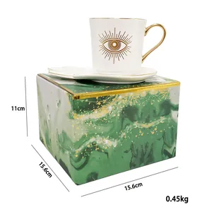 Detail view of gold-trimmed ceramic coffee cup set with marble texture gift box packaging