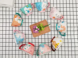 Top view of colorful ceramic mugs with hand-painted cartoon animals and macaron tones