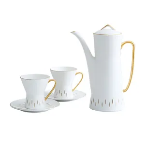 Modern white ceramic tea set with gold handles including a pot and two cup sets