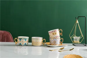 Vue détaillée de tasses à café en céramique ornée avec motifs géométriques et anses dorées